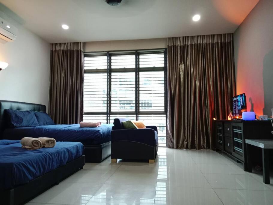 uma sala de estar com duas camas e um sofá em Palazio Mount Austin 2-4pax Entire Studio WiFi/TV Box em Johor Bahru