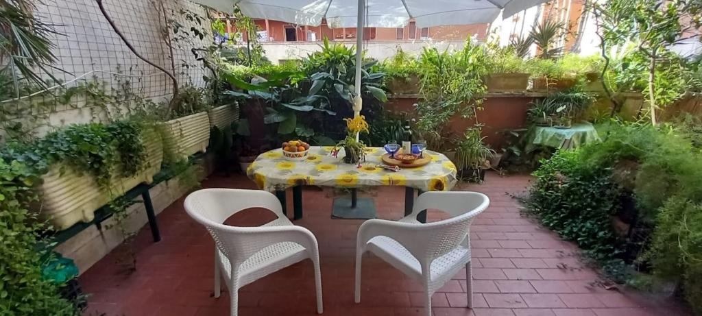 eine Terrasse mit einem Tisch und Stühlen im Garten in der Unterkunft Casa Dino in Rom