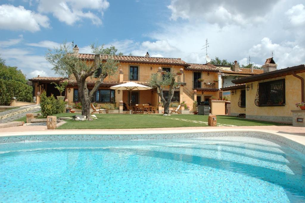 a large swimming pool in front of a house at Valle dei Casali B&B in Rome