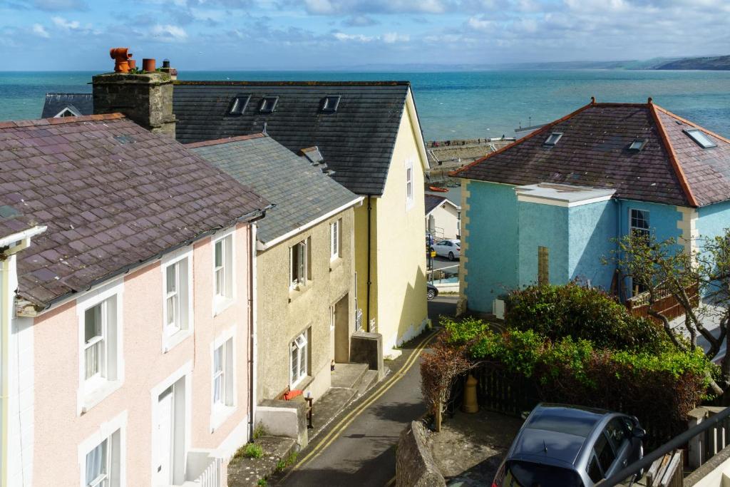 a row of houses with the ocean in the background at 1 White Street New Quay in New Quay