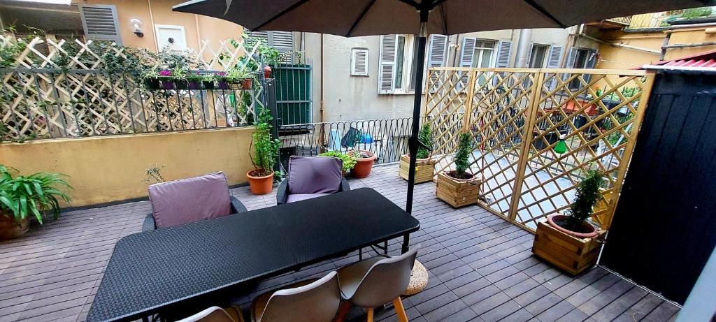un patio con mesa, sillas y sombrilla en ROCK&WHITE en Génova