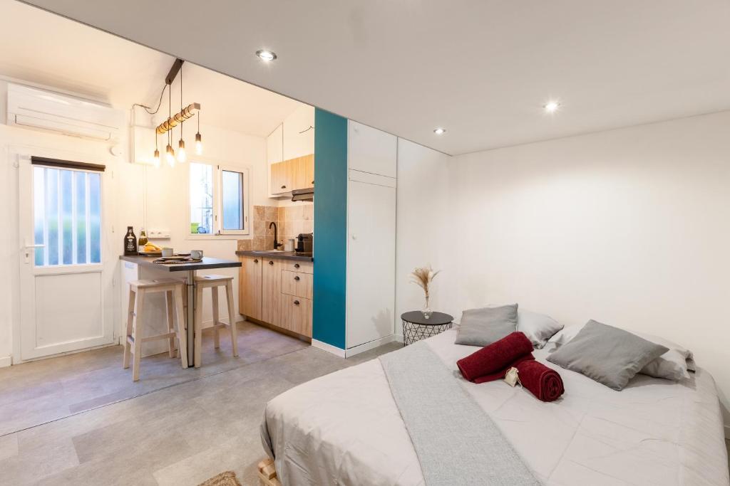 une chambre avec un grand lit et une cuisine dans l'établissement Le Cabanon du Vallon, à Marseille