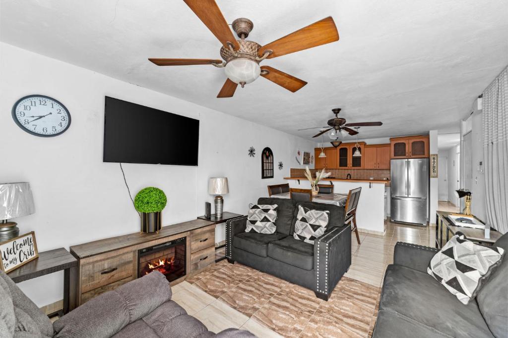 un soggiorno con divano e ventilatore a soffitto di Lupa Guesthouse affordable family home a Rincon