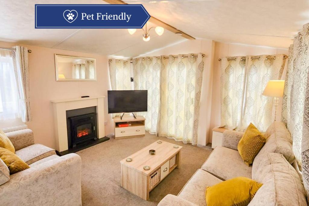 a living room with a couch and a fireplace at Serene Stay: Beautiful 2Bed Lodge in Kelsall in Kelsall