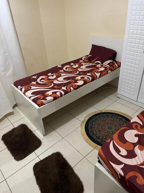un letto in una stanza con due tappeti sul pavimento di برج المحطة a Sharjah