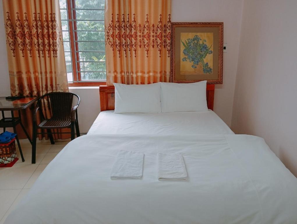 a white bed in a room with a window at Hien Thuc Hotel in Ninh Binh