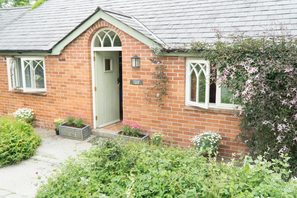 a red brick house with a white door at Thyme Lodge Drefach Felindre in Felindre