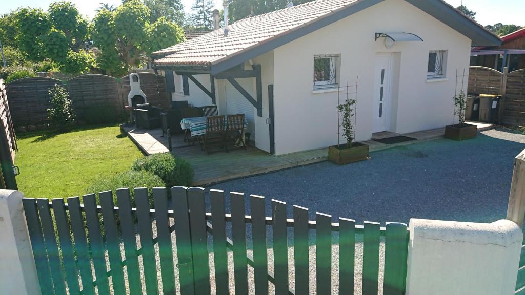 a white house with a fence in a yard at L'annexe de la Villa Darom, Andernos les bains. in Andernos-les-Bains