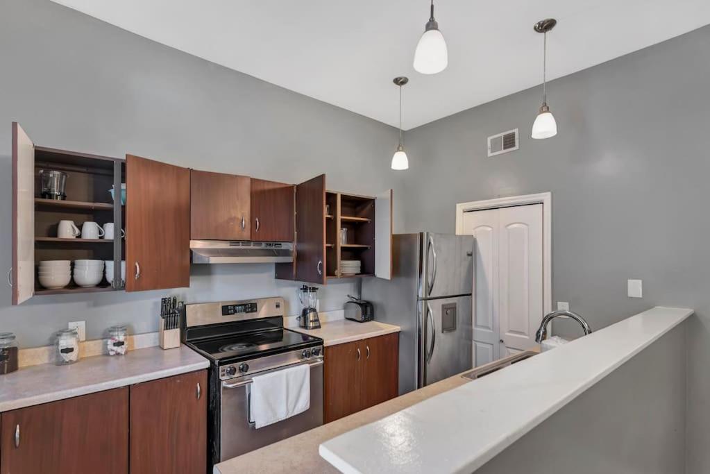 a kitchen with stainless steel appliances and wooden cabinets at Breathtaking Unit in Shaw - 4 Queen beds 1W in Tower Grove