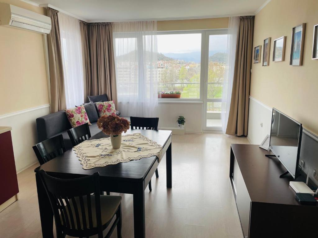 プロブディフにあるRIVERSIDE APARTMENTS PLOVDIV 1 with free parkingのテーブルと椅子と大きな窓のあるダイニングルーム
