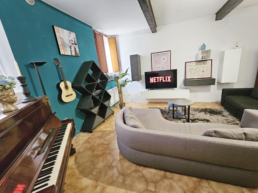 een woonkamer met een bank en een piano bij AMA Ferrara in Ferrara