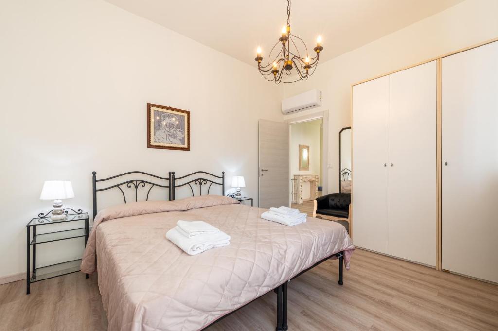 a bedroom with a large bed with two towels on it at Oltretorrente Ospedale Apartment in Parma