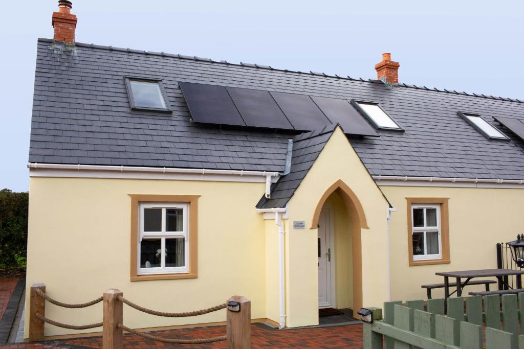 een huis met zonnepanelen op het dak bij Tudor Cottage Manorbier in Manorbier