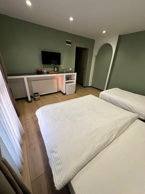a hotel room with two beds and a flat screen tv at Heaven Inn Airport Hotel in Arnavutköy