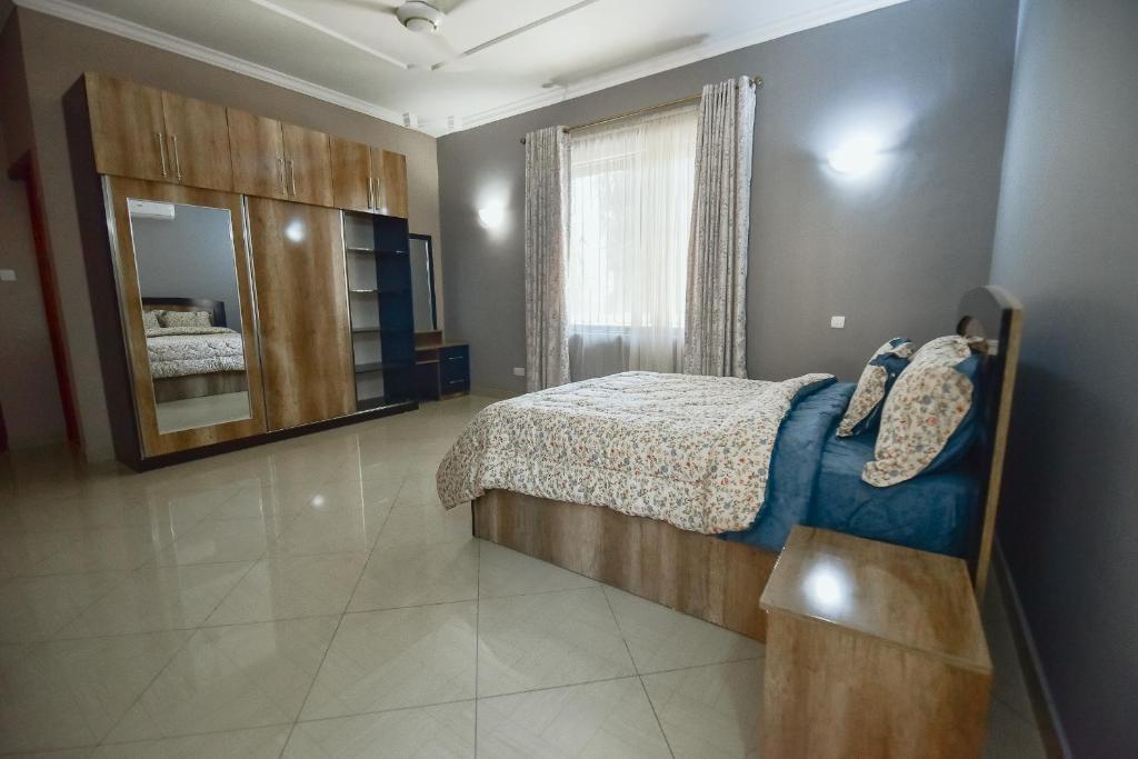 1 dormitorio con cama y espejo grande en GOWON BnB BUNJU, en Nasulo