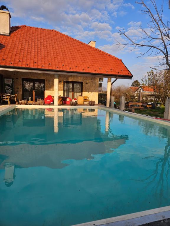 una piscina vacía frente a una casa con techo naranja en Boletov raj lux, en Čurug