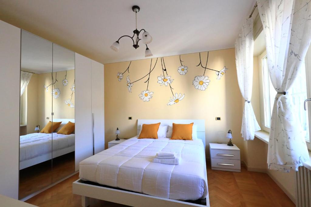 a bedroom with a white bed and a mirror at DA MEGGY in Stresa