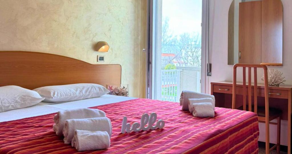 una camera da letto con un grande letto con asciugamani di Hotel Caruso a Rimini