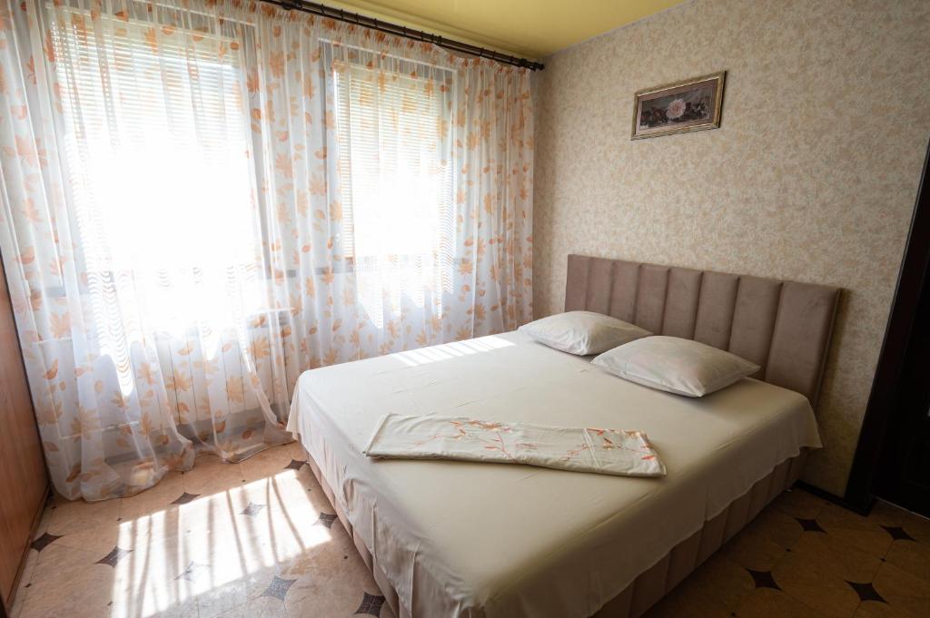 Schlafzimmer mit einem Bett und einem Fenster mit Vorhängen in der Unterkunft Героїв Дніпра, 53, 3-й поверх, квартира біля пляжу Живчик in Tscherkassy