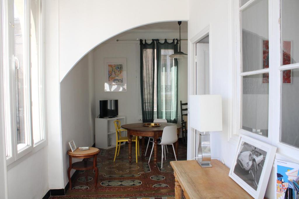 a hallway with a table and a dining room at Superbe appartement avec parking sur place in Nîmes
