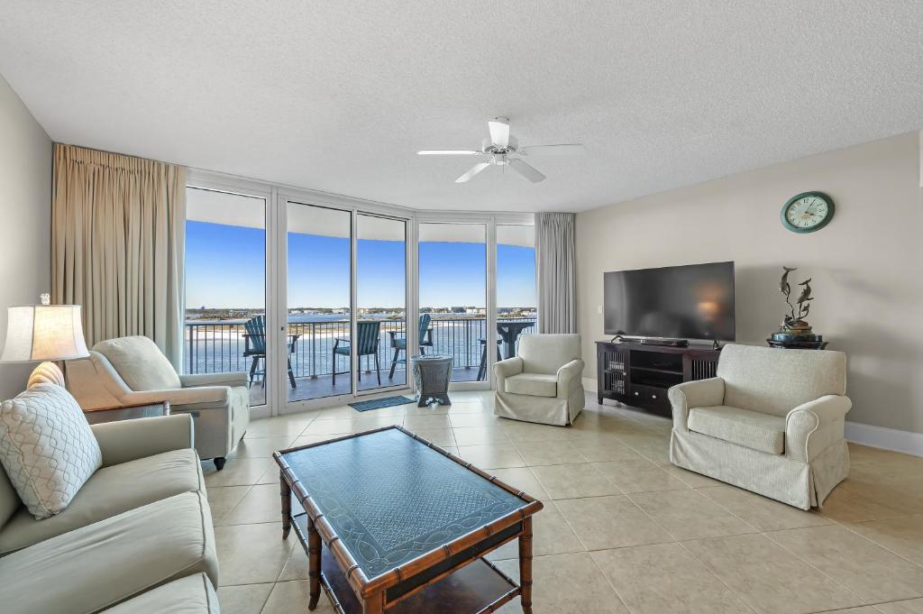 un soggiorno con divano, sedie e TV di Caribe Resort Unit B603 a Orange Beach