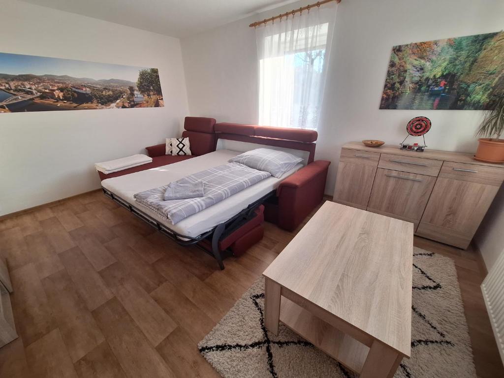 Un dormitorio con una cama y una mesa. en Pod Chlumem - útulný byt v blízkosti centra, en Děčín