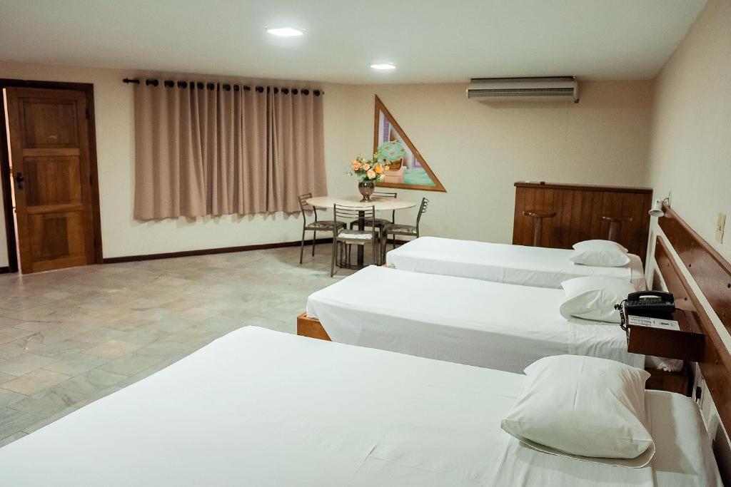 una habitación de hospital con 4 camas y una mesa en Sakr Hotel, en Penápolis