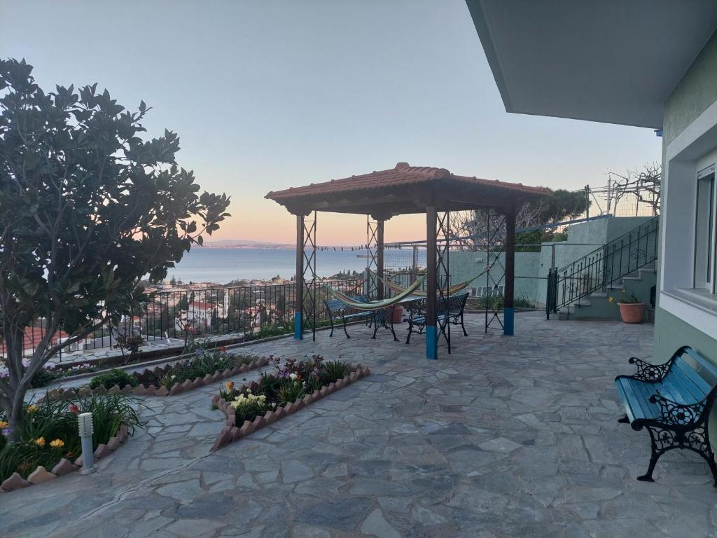 eine Terrasse mit Bänken und einem Pavillon in der Unterkunft Depys' View in Chios