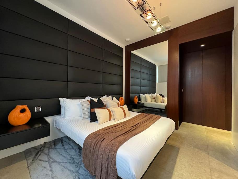 a bedroom with a large bed with a black wall at Hyde Park Central South Kensington in London