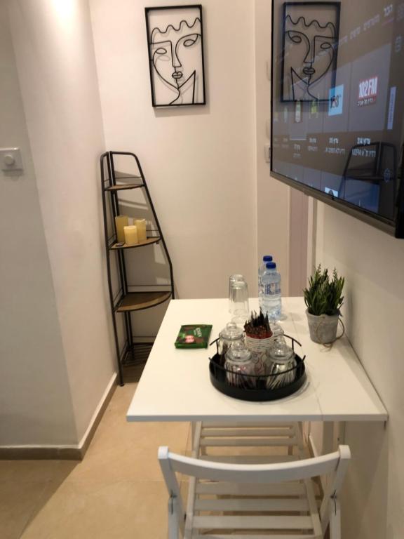 mesa con silla y TV en la pared en Boutique Suite Talia, en Eilat
