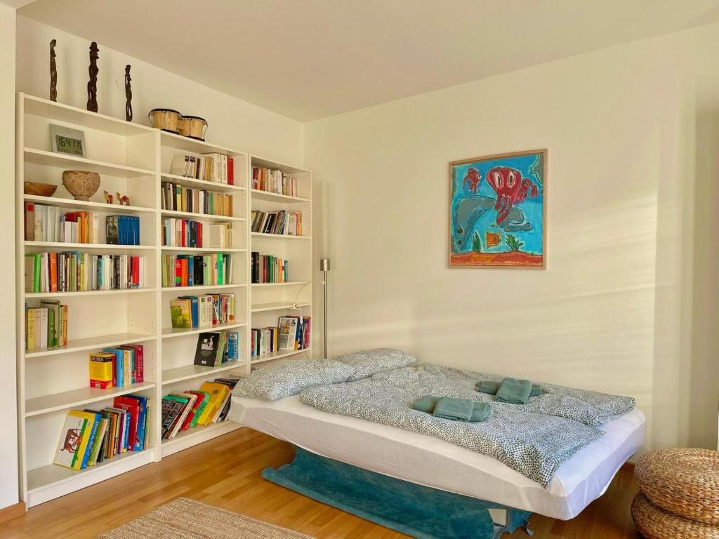 1 dormitorio con cama y estanterías con libros en Elegantes Haus - direkt am Domplatz - Garage, en Erfurt