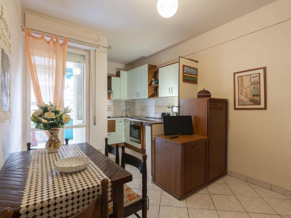 Una sala de estar con una mesa y una cocina. en Apartment Fulvia by Interhome, en Santo Stefano al Mare