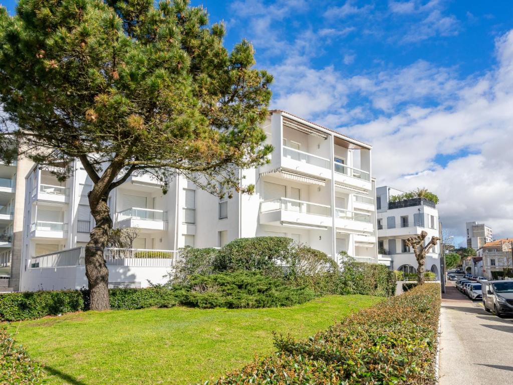 un edificio de apartamentos con un árbol delante de él en Apartment La Plage by Interhome, en Esplanade de Pontaillac