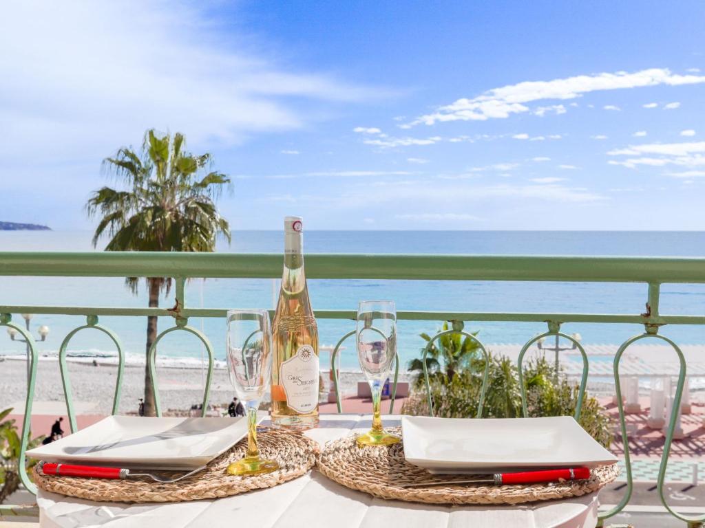 ニースにあるApartment Les Yuccas Promenade des Anglais by Interhomeのビーチでのワイン1本とグラス1杯