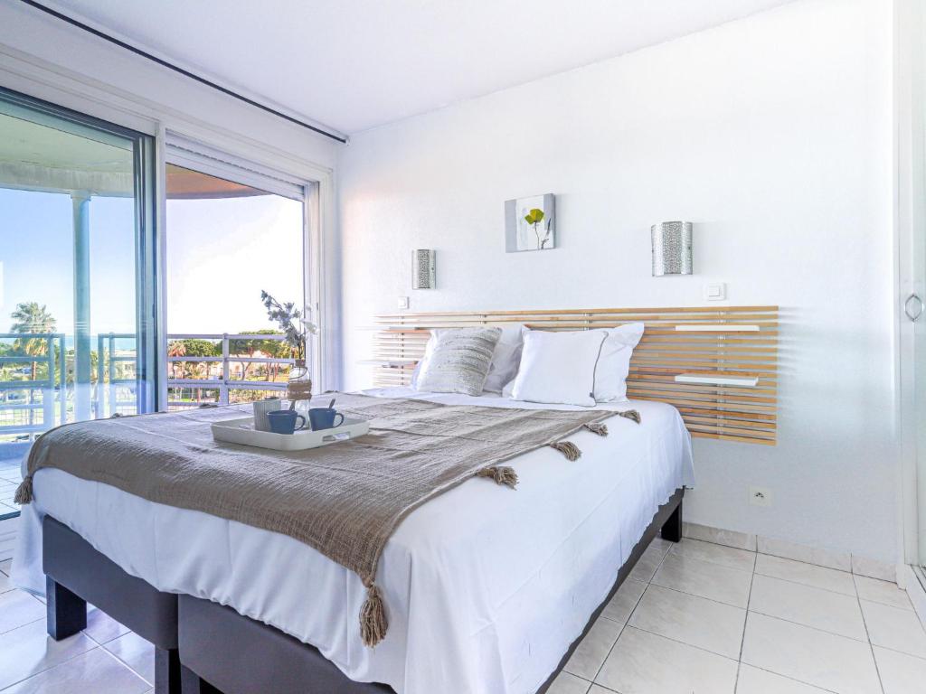 1 dormitorio con 1 cama grande y ventana grande en Apartment Le Frémont by Interhome, en Niza