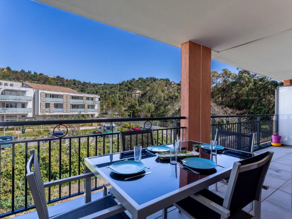 a dining table on a balcony with a view at Apartment Le Jardin du Loderi-2 by Interhome in Bormes-les-Mimosas