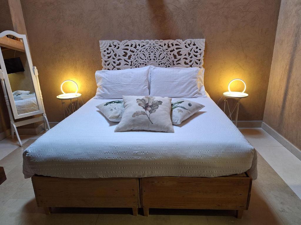 a bed with two pillows on it with two lamps at Vallarom in Avio