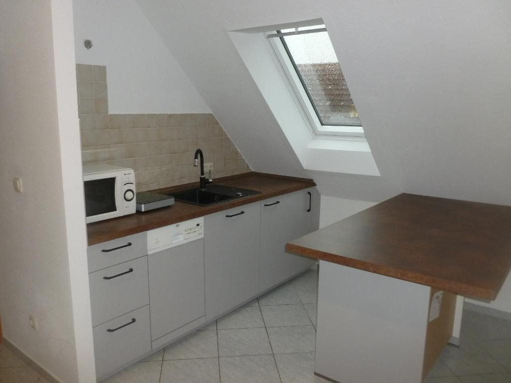 a kitchen with white cabinets and a sink and a window at Elegant & Modern - Apartment Scarlett in Neuburg an der Donau