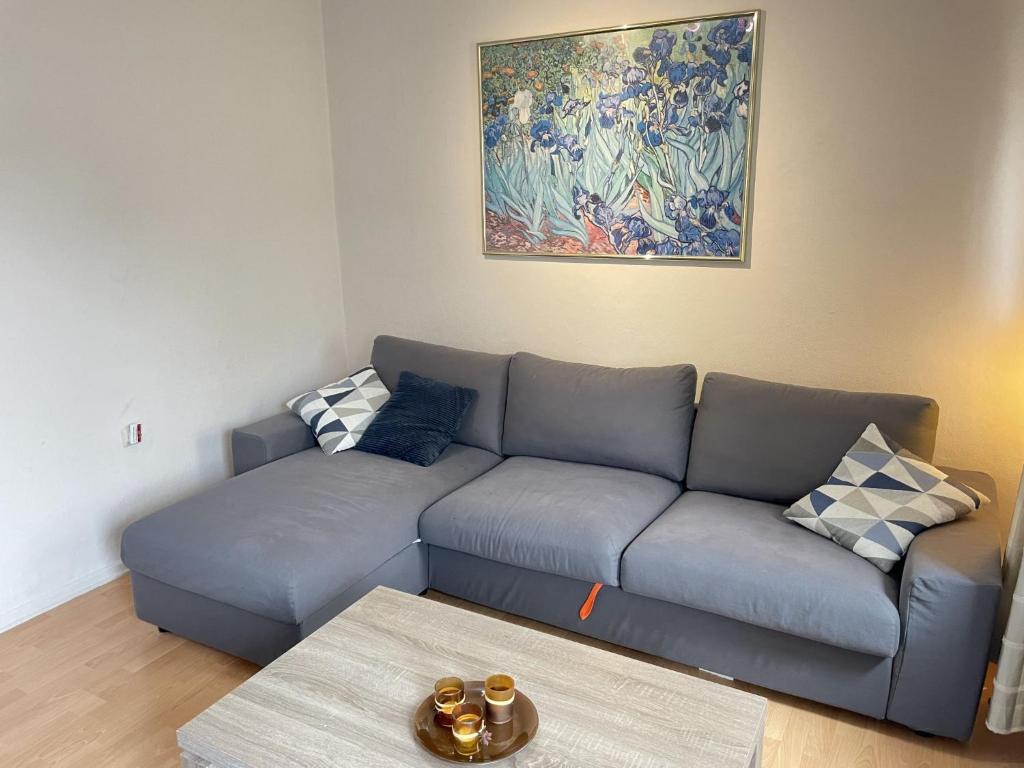 un soggiorno con divano blu e un dipinto di Apartment Nordlicht by Interhome a Bremerhaven