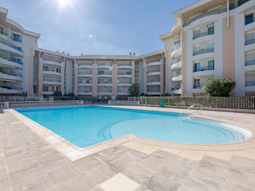 une piscine en face d'un grand immeuble dans l'établissement Apartment L'Open-10 by Interhome, à Fréjus