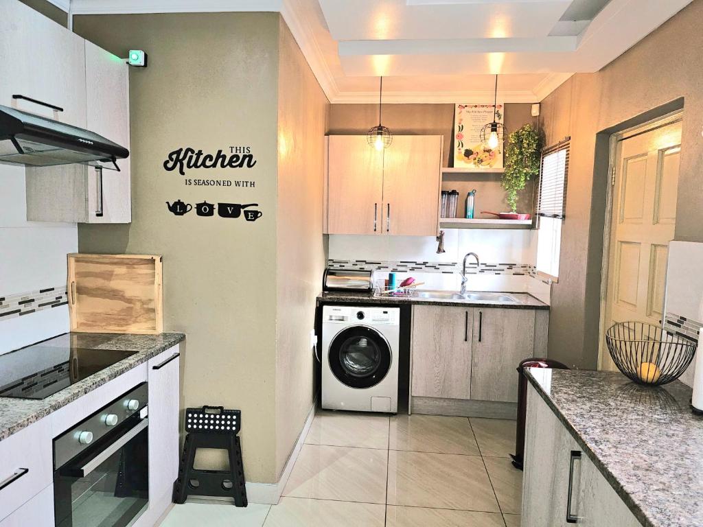 a kitchen with a washing machine and a sink at Downham Views in Johannesburg