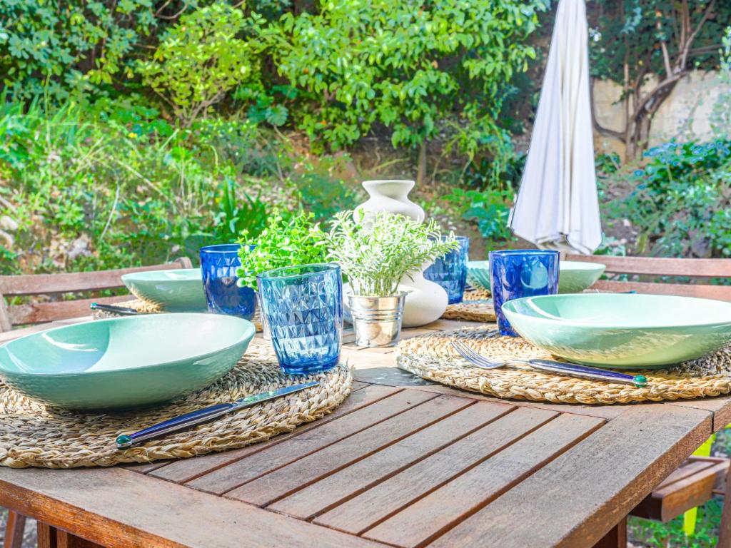 une table en bois avec des bols bleus et des assiettes dessus dans l'établissement Apartment Le Palais Niçois by Interhome, à Nice