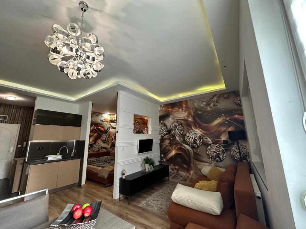 a living room with a couch and a chandelier at Füredi Apartman in Debrecen