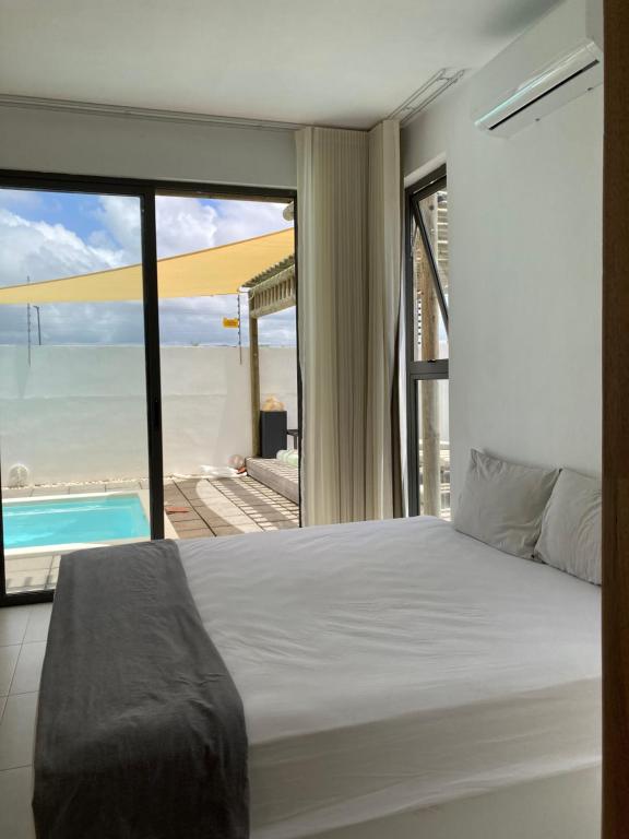 a bedroom with a bed and a view of the ocean at Villa Trou d'Eau Douce in Trou dʼ Eau Douce