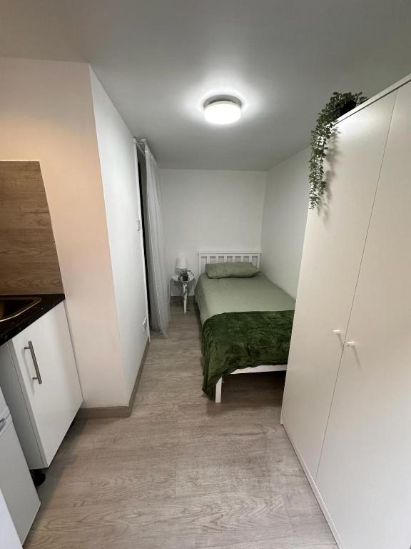 ein kleines Schlafzimmer mit einem Bett in einem weißen Zimmer in der Unterkunft Single ensuite room in London