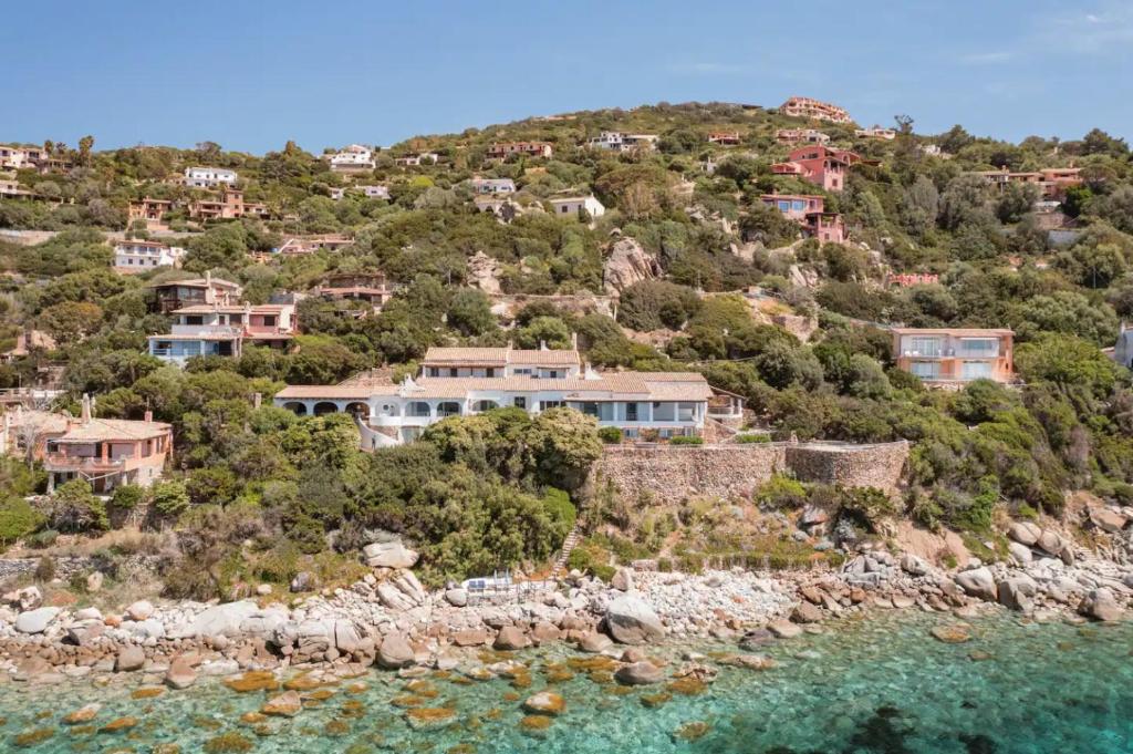 eine Gruppe von Häusern auf einem Hügel neben dem Wasser in der Unterkunft Villa Stella Turchese - IUN F0243 in Torre delle Stelle