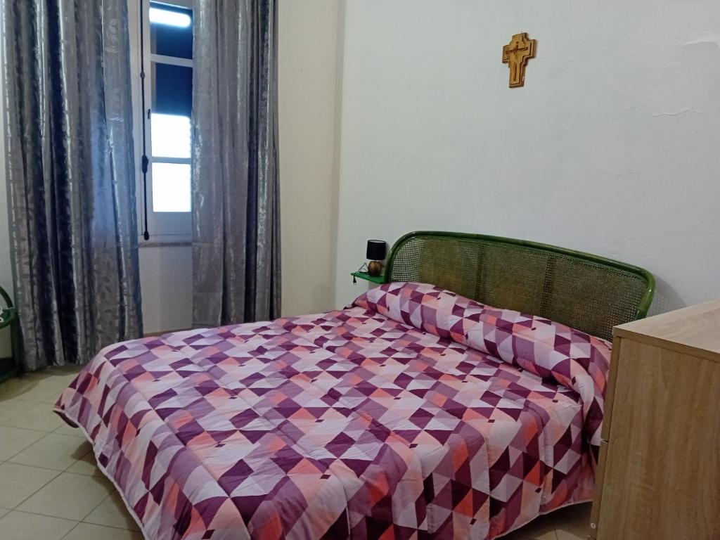 una camera con un letto e una croce sul muro di Casa Mercedes a Pau
