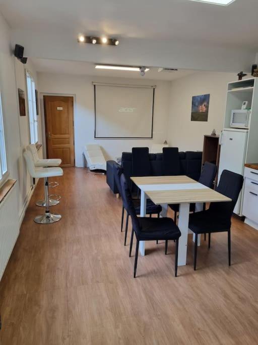 une salle de conférence avec des tables et des chaises et un tableau blanc dans l'établissement Maison au bord de Marne, à Maisons-Alfort