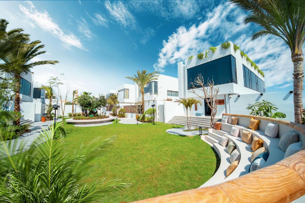 an exterior view of a house with a lawn and palm trees at Nas House Private Villas in Dubai