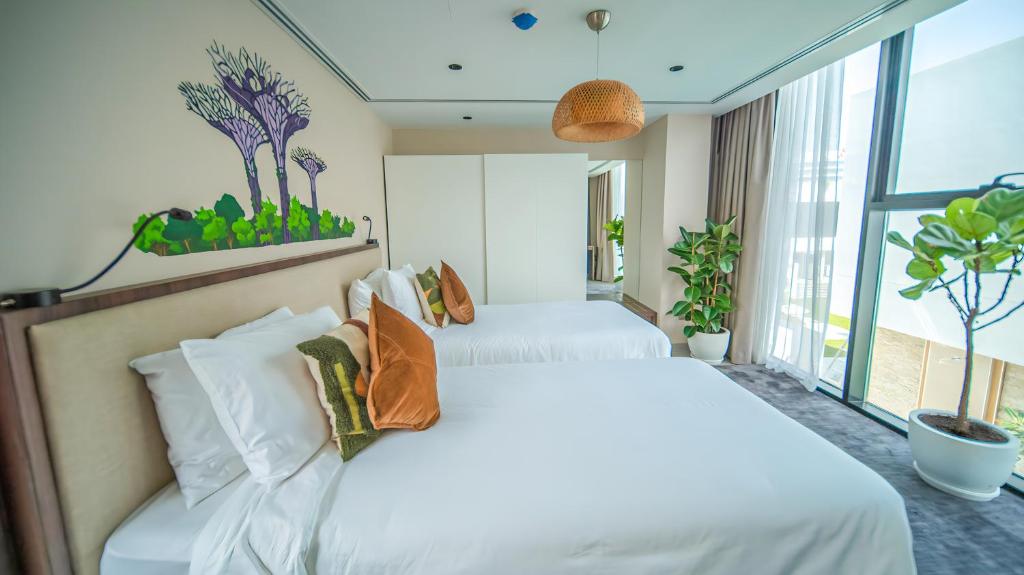 2 witte bedden in een kamer met een raam bij Nas House Private Villas in Dubai